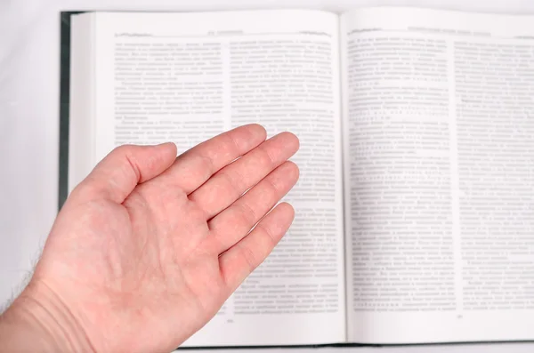 Dłoń pokazuje otwartą książkę. — Zdjęcie stockowe