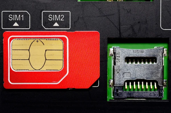 Red SIM card on slots in mobile phone. — Stock Photo, Image