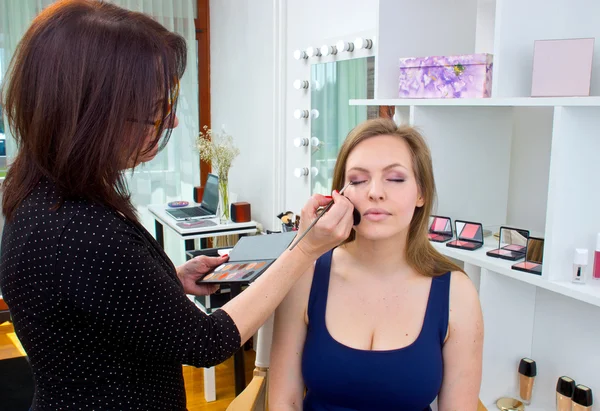 Maquillaje artista aplicar sombra de ojos en los ojos de las mujeres —  Fotos de Stock