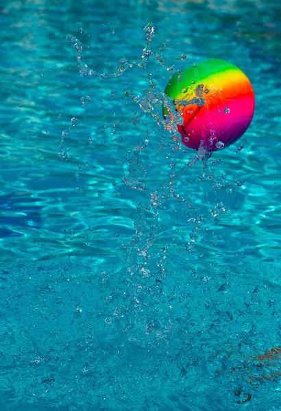 Palla da spiaggia spruzzando acqua in piscina — Foto Stock