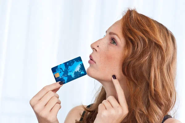 Mulher sardenta segurando cartão de crédito — Fotografia de Stock