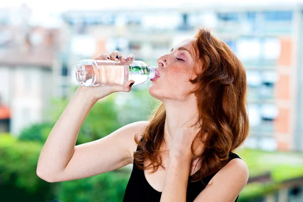 Mujer pecosa bebe agua de la botella Imagen de archivo