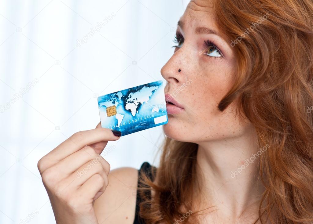freckled woman holding credit card