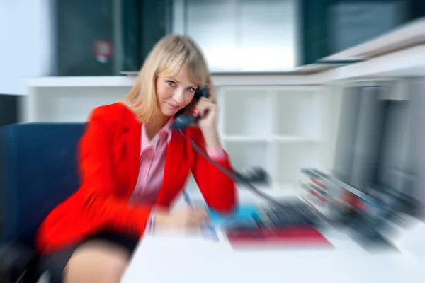 Attractive blond woman in office talking to phone — Stock Photo, Image