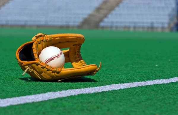 Бейсбольная перчатка и мяч на поле — стоковое фото