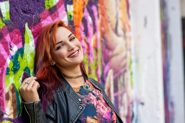 Moderna ragazza urbana di fronte al muro graffiti — Foto Stock