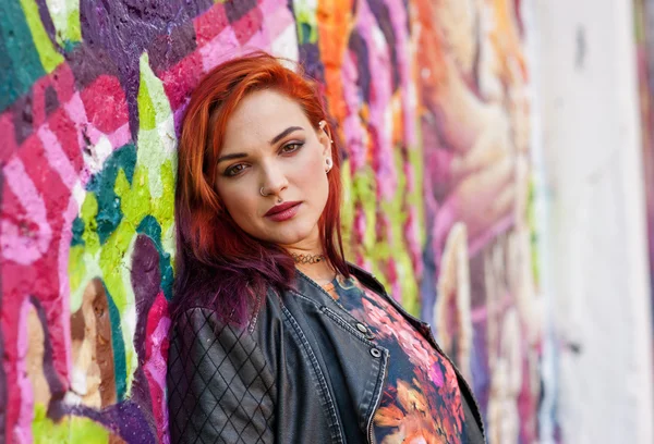Modern urban girl in front of graffiti wall — Stock Photo, Image