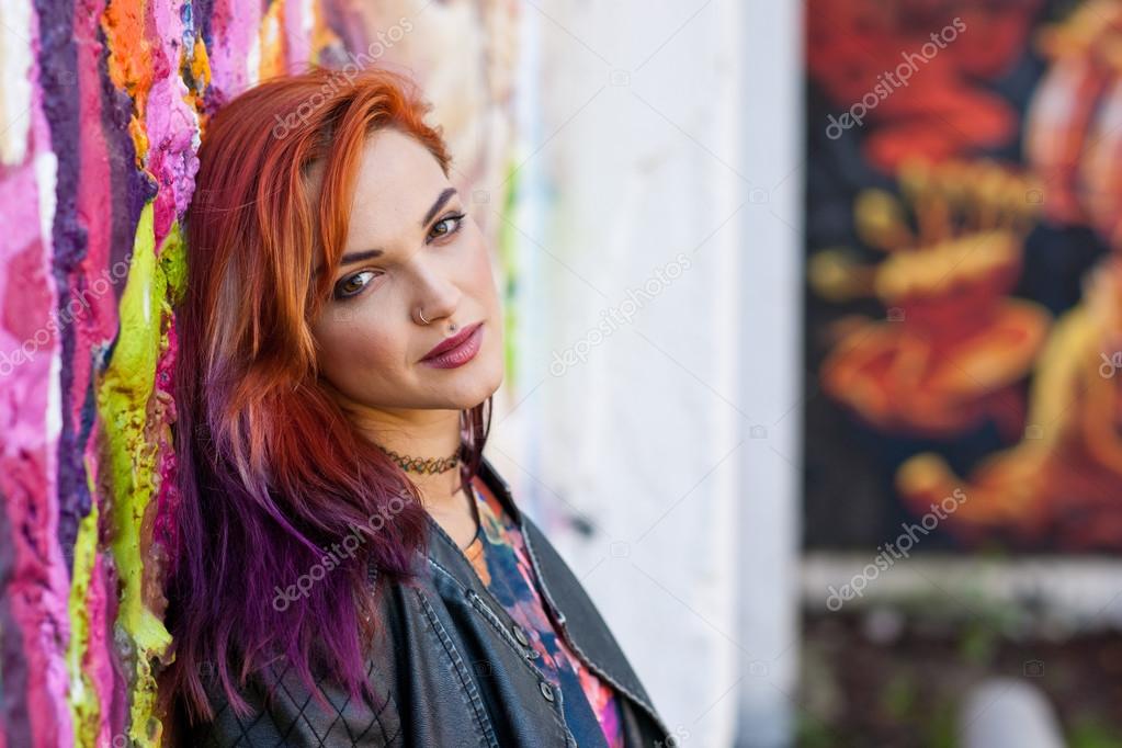 modern urban girl in front of graffiti wall