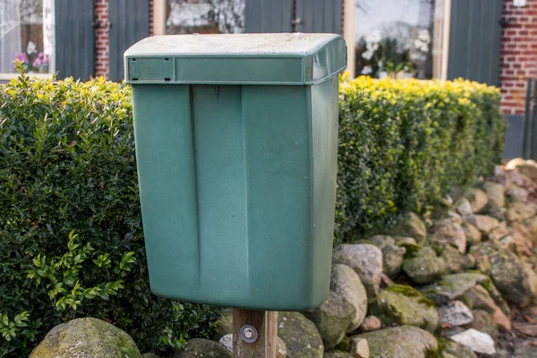 Eski bir evdeki çitlerin ve taşların yanındaki posta kutusu.