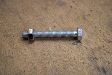 Bir çalışma odasındaki kontrplak arka planında cıvata ve fındık büyüklüğünde M8.