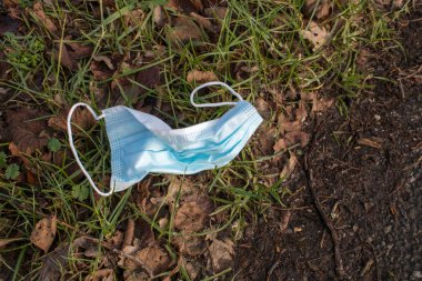 Tek kullanımlık kulak ilmiği koruyucu yüz maskesi çöplüğü. COVID-19 salgınında atık