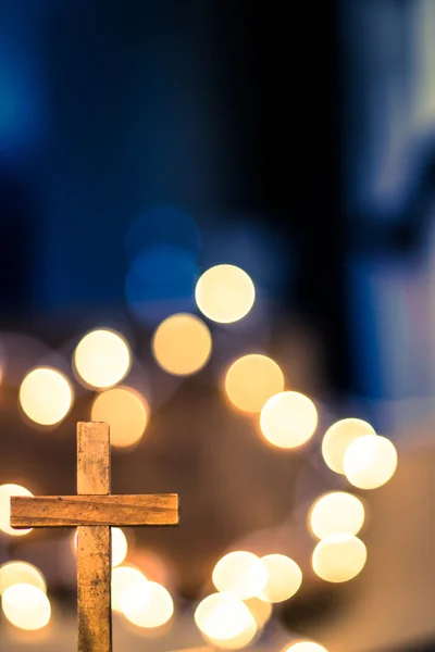 Dřevěný kříž a rozostřeného světla — Stock fotografie