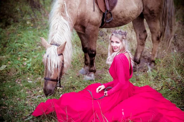 Beautiful woman in crown, blonde with light gray horse. Princess in fairy tale. Fantasy autumn