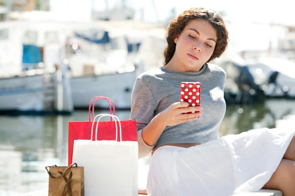 Mujer en puerto de yates con bolsas de compras — Foto de Stock