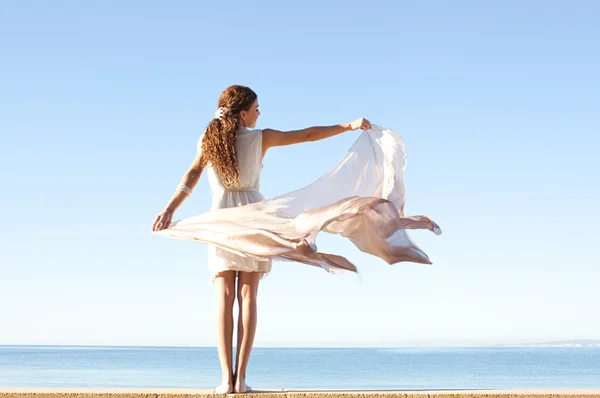 Panoramiczny widok z tyłu młoda kobieta trzymając pływających tkaniny jedwabne z jej ręce z jasnego nieba na wakacje, Podróże na zewnątrz. urody i zdrowego stylu życia — Stockfoto