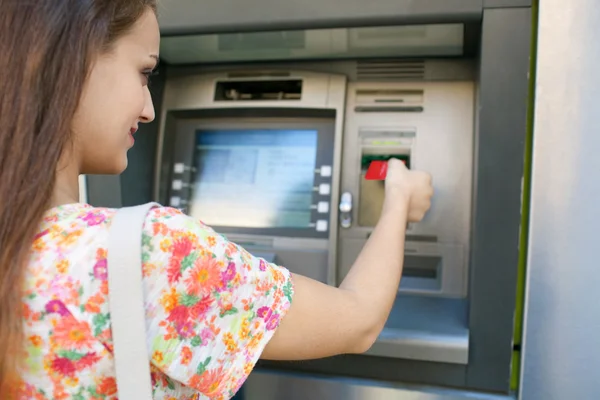 Woman using a cash point machine — Stockfoto