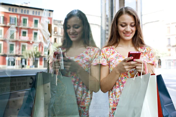Привлекательная женщина за покупками со смартфоном — стоковое фото