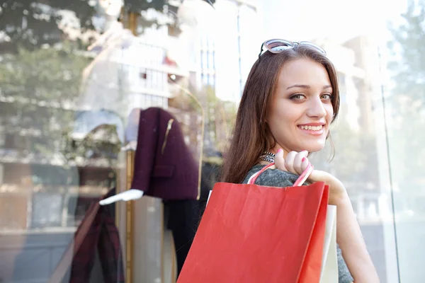 Kvinnan bär shoppingväskor — Stockfoto