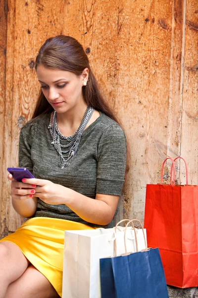 Mujer con bolsas de compras y smartphone — Foto de Stock