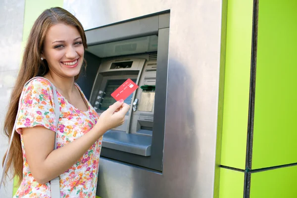 Woman using a cash point machine — Stockfoto