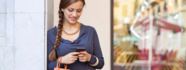 Vrouw met shopping tassen en telefoon — Stockfoto