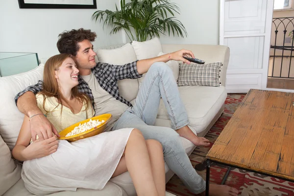Couple watching television, eating pop corn — Stok fotoğraf