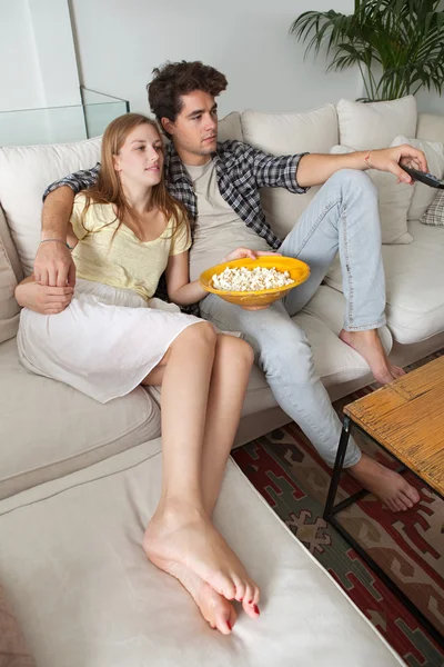 Casal assistindo televisão, comendo milho pop — Fotografia de Stock