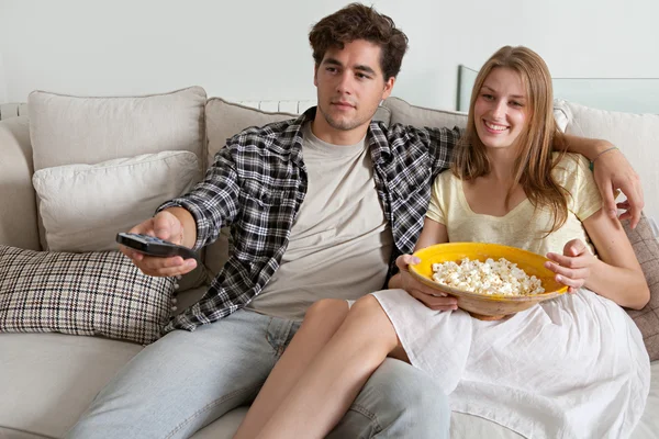 Couple watching television, eating pop corn Royalty Free Stock Photos