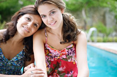 teenager daughter and her mother hugging