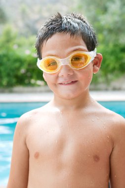 portrait of a boy relaxing by a swimming pool
