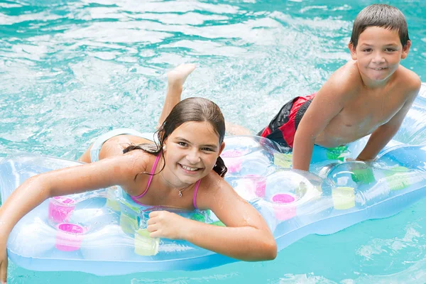 Дети плавают вместе в голубом бассейне — стоковое фото