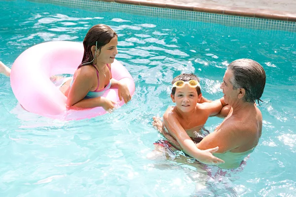 Família nadando juntos em uma piscina — Fotografia de Stock