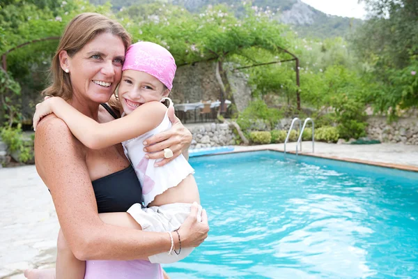 Madre llevando a su hija pequeña en sus brazos — Foto de Stock