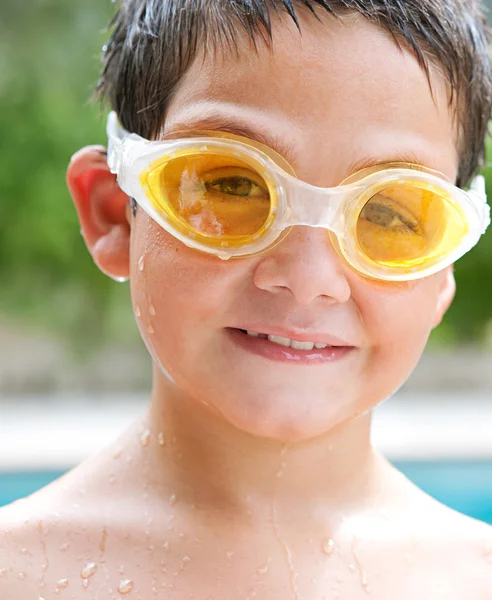 Portrait of a boy relaxing by a swimming pool — Stockfoto