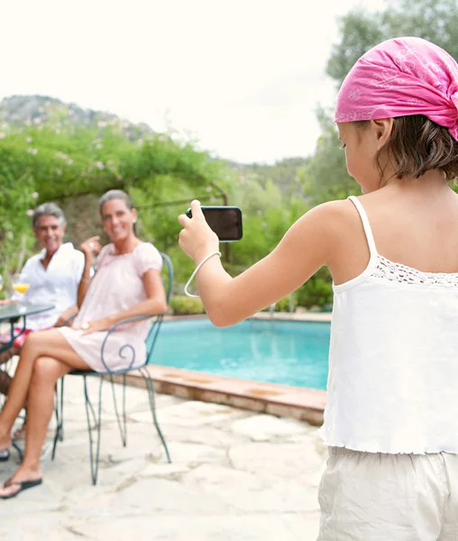 Daughter pointing a digital photo camera at her parents — Stockfoto