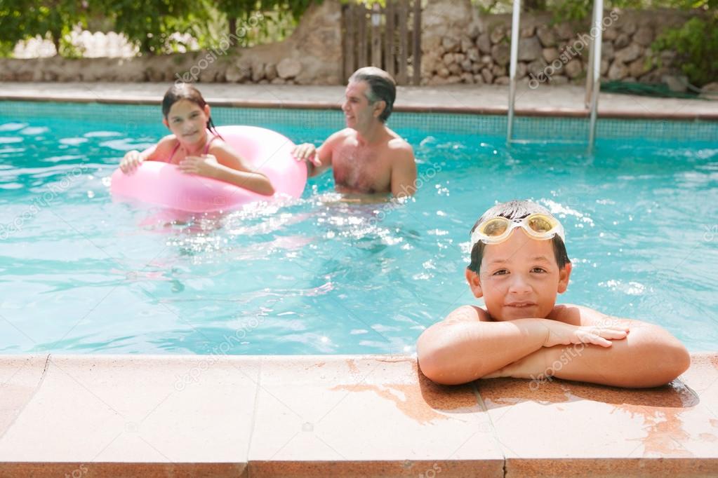 family swimming together in a pool