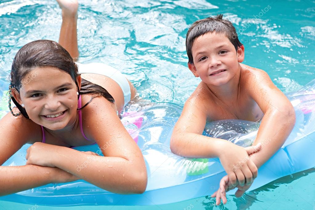 Children swimming together in a blue pool Stock Photo by ©mjth 78501282
