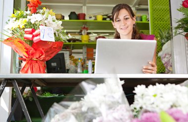florist woman using a laptop in her store