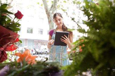 florist woman with a clipbard in her store