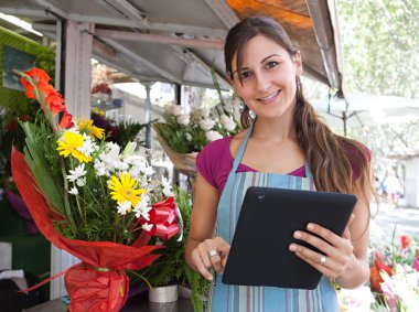 florist woman with a clipbard in her store