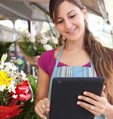 florist woman with a clipbard in her store