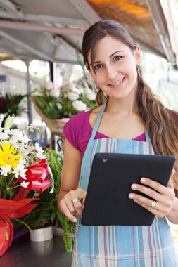 florist woman with a clipbard in her store
