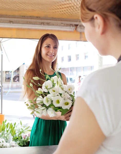 Mulher compra um buquê de flores — Fotografia de Stock