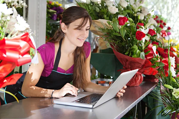 florist woman using a laptop in her store