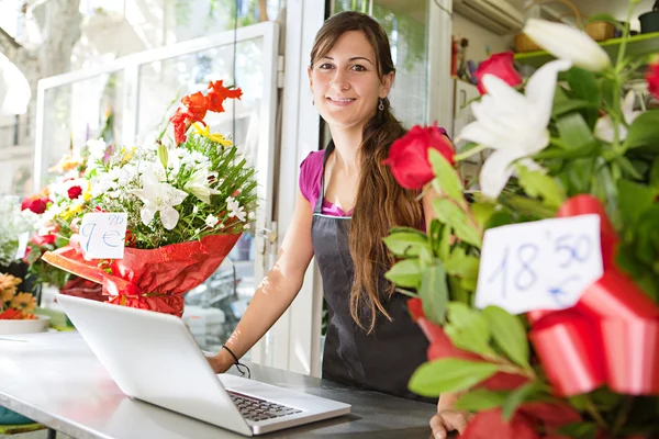 florist woman using a laptop in her store
