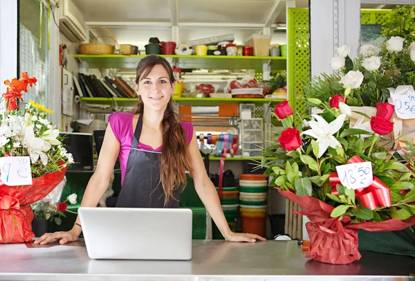 Fleuriste femme à l'aide d'un ordinateur portable dans son magasin — Photo