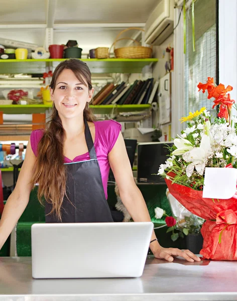 Fleuriste femme à l'aide d'un ordinateur portable dans son magasin — Photo