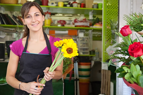 Florist woman works in her store — Stok fotoğraf
