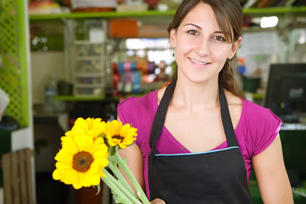 Florist woman works in her store — Stockfoto