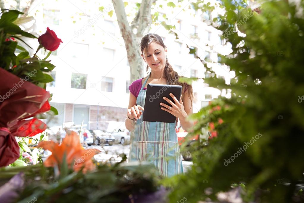 florist woman with a clipbard in her store